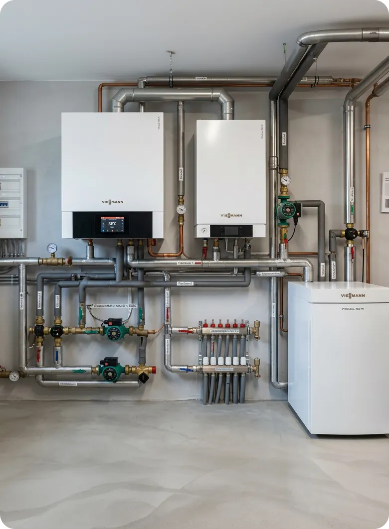 Heizungsanlage mit W&auml;rmepumpe und Speicher im Technikraum von Maibach Bau