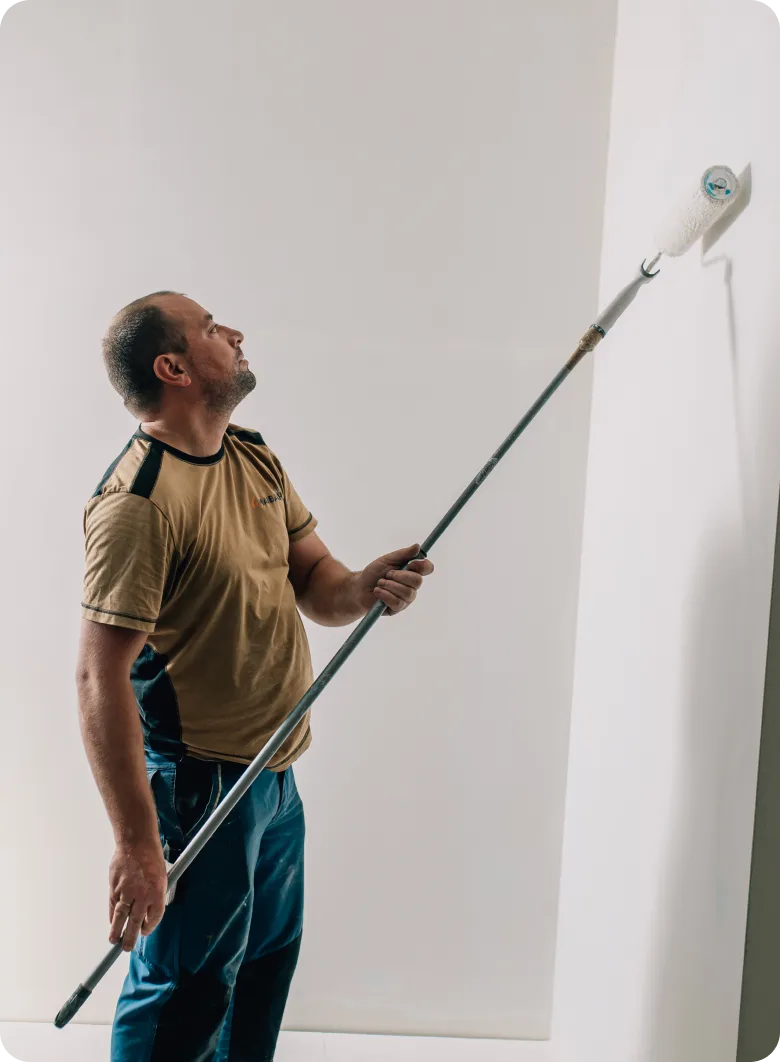 Maler von Maibach Bau streicht die Decke mit dem Teleskoproller