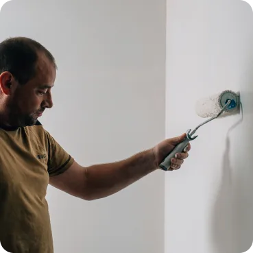 Innenanstrich-Referenz: Maler beim Streichen einer Wand