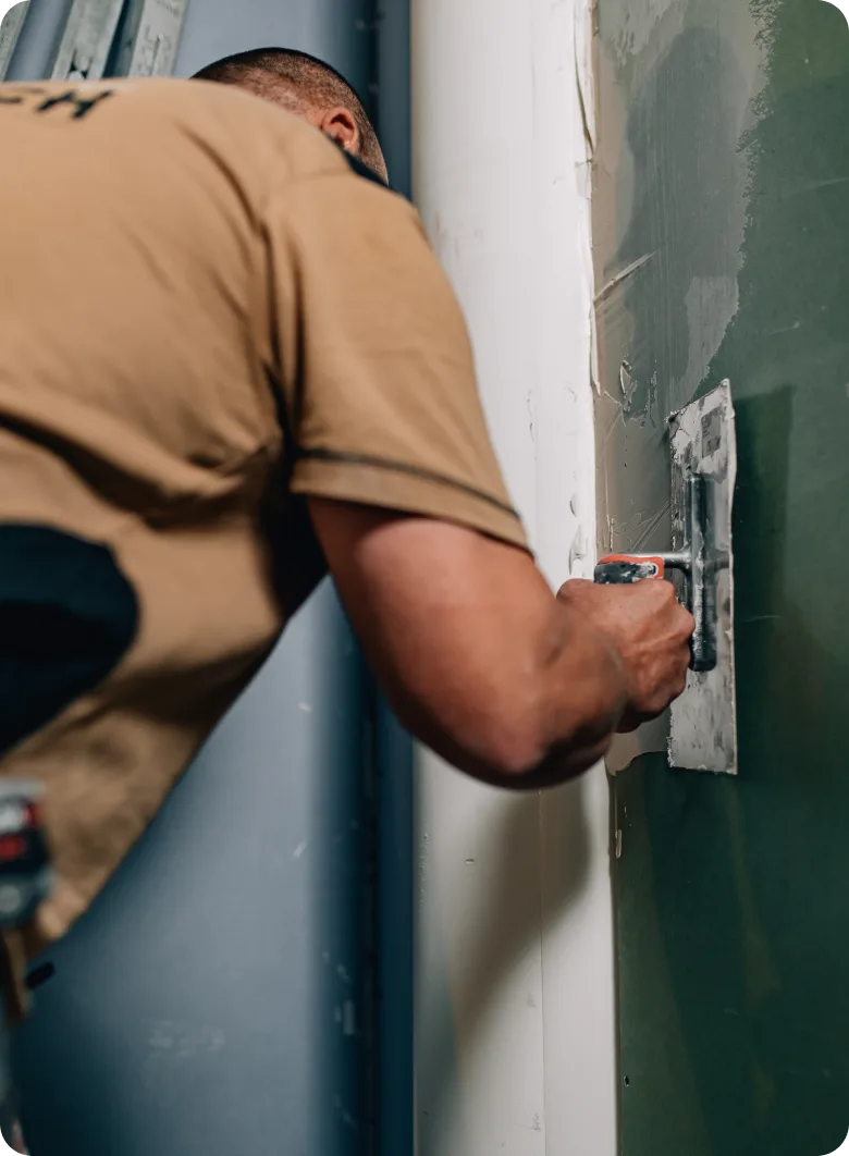 Fachkraft von Maibach Bau beim Glätten einer Wand mit der Glättkelle